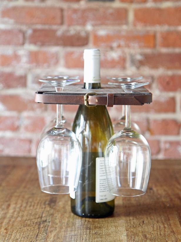 Make an upcycled wine glass holder using an old leather belt and a scrap piece of wood.