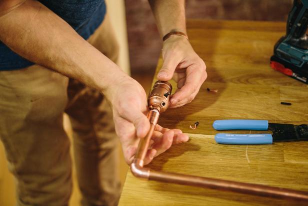 Attach lamp parts to piping to make an industrial-style sconce.