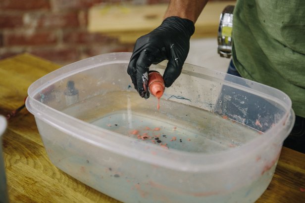 Add drops of the second nail polish color to a container of water.