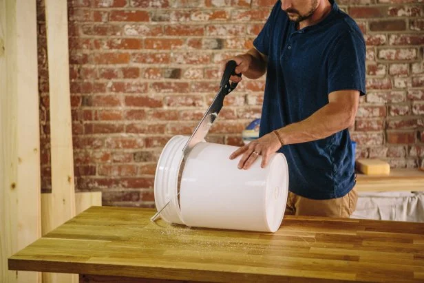 Cut the top of the bucket using a hand saw.