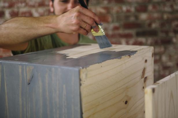 Apply stain to the cabinet using a paintbrush.