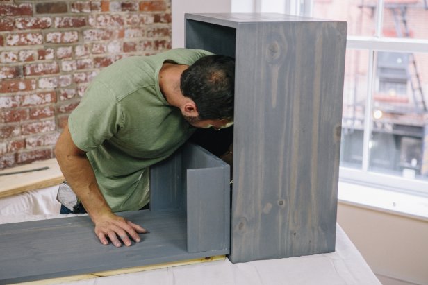 Attach door to cabinet frame using a piano hinge.