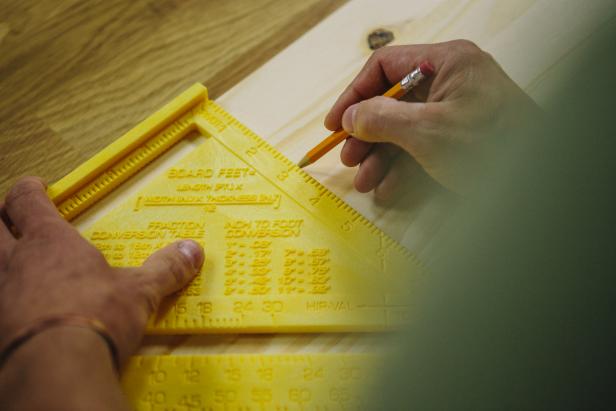 Measure and draw a line on a wood piece to make a cabinet.