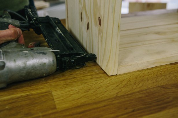 Create cabinet frame by attaching wood pieces using a nail gun.