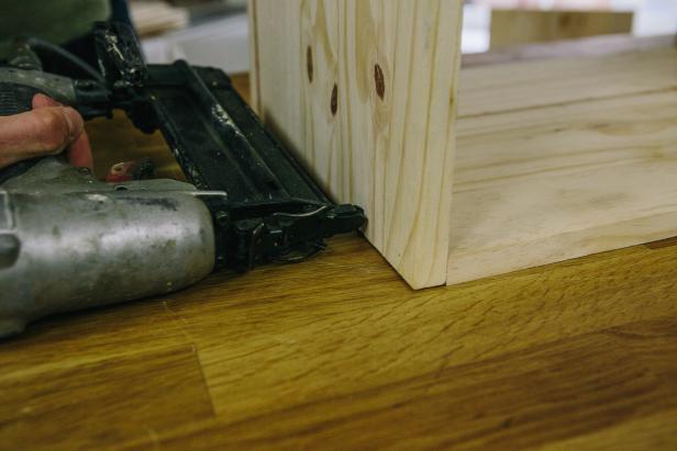 Create cabinet frame by attaching wood pieces using a nail gun.