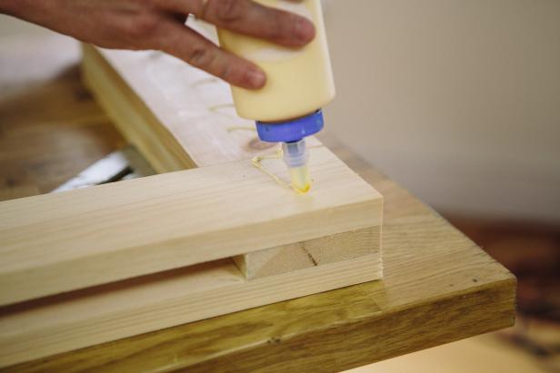 Apply glue in between wood pieces to make a bench.