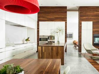Kitchen With Sleek White Cabinets, Wood Islands and Concrete Floors