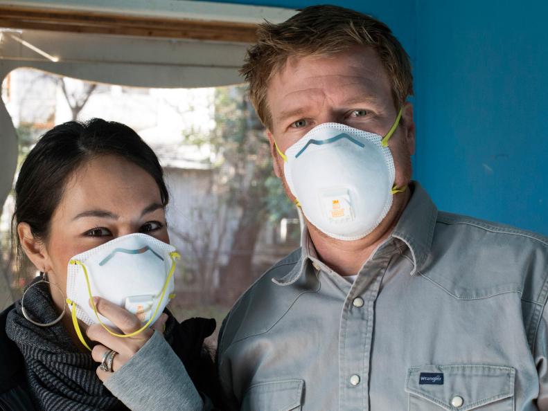 Fixer Upper Hosts Chip and Joanna Gaines wear masks on demolition day at Kelly and Clint Harp's home.  The old home has fallen into disrepair and is full of junk and trash, as seen on HGTV's Fixer Upper.  (portrait)