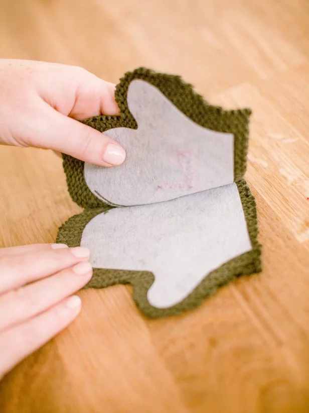 Once the interfacing is attached, place the two sides of the mitten together, then, using a blanket stitch, join together to create a pocket for treats, leaving the top of the mitten open for inserting treats.