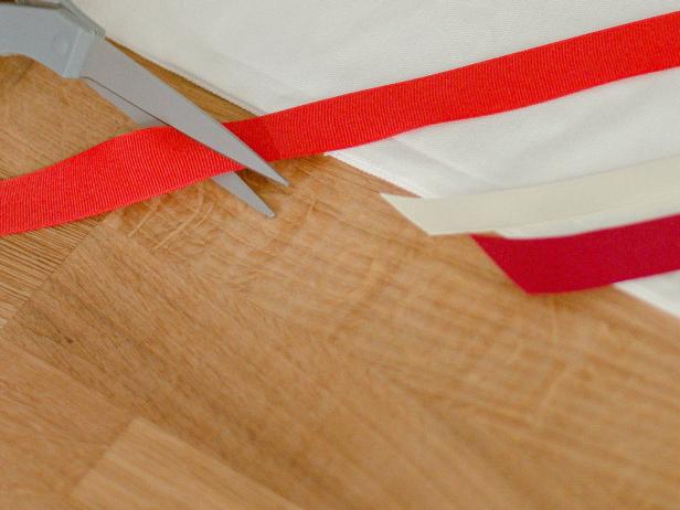 Once the ribbons are adhered to the pillow cover, neatly trim the excess ribbon along the edges.