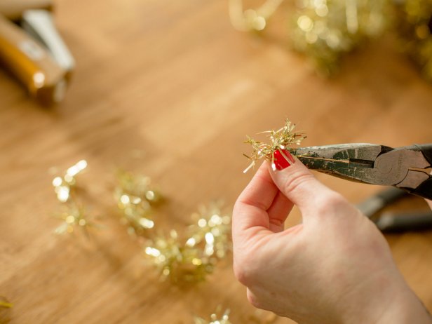 If you're using tinsel wire, use wire cutters to snip into small pieces, then use needle nose pliers to bend each section into a ball shape so that it stands up well inside the ornament.
