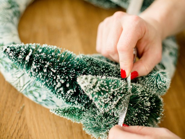 Cut an 18-inch piece of ribbon and lace it through the trees so that it's loosely draped across the bottom of the wreath. Hot glue ribbon into place, as needed.