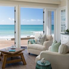 Beach House Living Room with Large Glass Doors, Overstuffed Armchairs and Hardwood Floors
