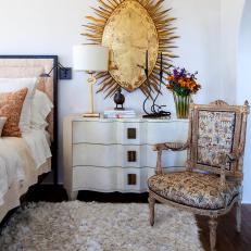 White Bedside Table with Large Metal Hanging Art, Shag Rug and Upholstered Chair