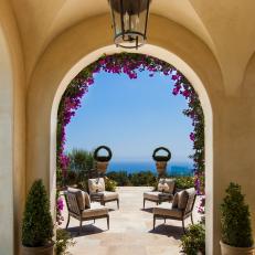 Outdoor Space with Loggia Arch, Magenta Flowers, Stone Floors and Ocean View