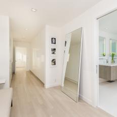 Modern Home White Hallway with Large Leaning Mirror and Hardwood Floors