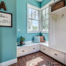 Mudroom With Brick Floor, Turquoise Walls & White Cabinets
