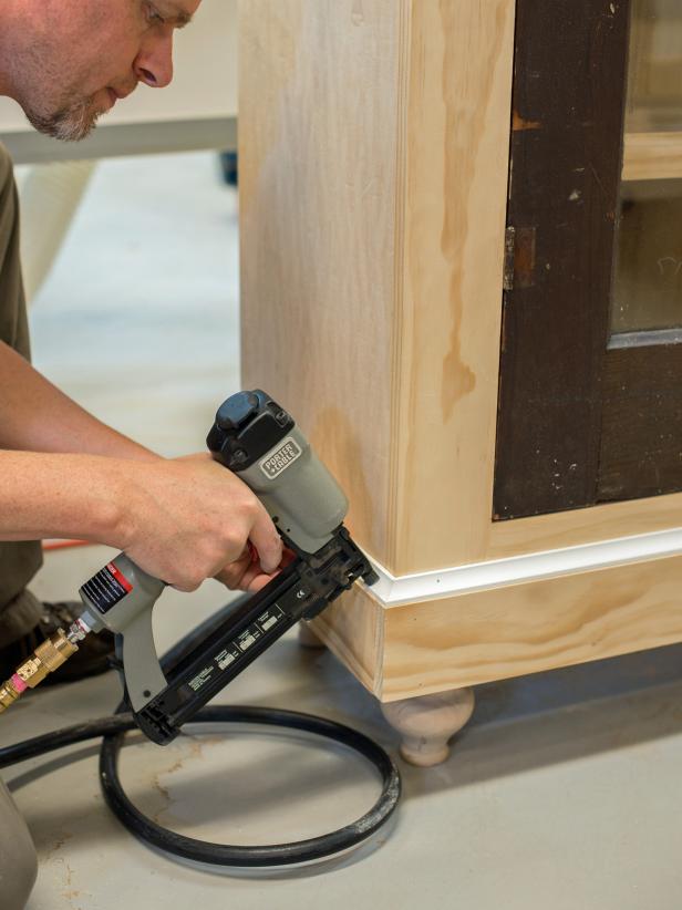 With brad nails (1-1/4” or 3/4” depending on size of trim), tack in 1 x 4” boards, cut to size, into top and bottom of cabinet. Add decorative molding as desired, cutting to size of a miter saw. Paint, stain or finish as desired.