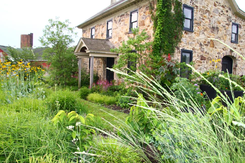 A garden in front of a stone house