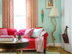 Round Coffee Table in Front of Red Sofa Covered With Throw Pillows