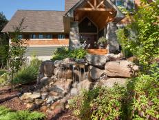 Front Yard Waterfall With Boulder Landscape Shaping and Surrounding Garden 