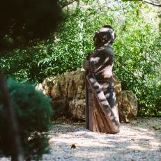 Solitary Japanese Statue Blends Seamlessly Into Asian Garden