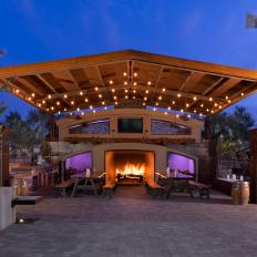 Modern Outdoor Dining Area with Wood Pergola, Picnic Tables and Fireplace