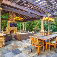 Outdoor Dining Room With Long Wood Table and Lantern Centerpieces Under Cedar Cover 