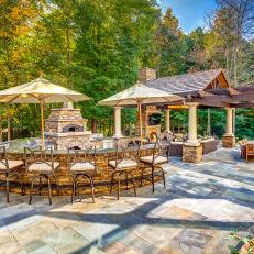 Outdoor Living Space on Bluestone patio With Kitchen Featuring Long Bar For Outdoor Dining 