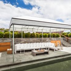 Long Contemporary Outdoor Sectional WIth Stacked White Pillows, Low Asian Coffee Table and White Tent Cover 