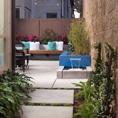 Small Backyard With Blue Block Planter and Retaining Wall