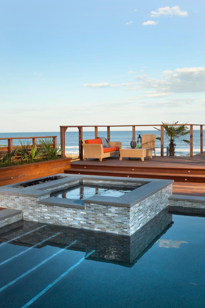 Brown Wood Deck and Gray Mosaic Tile Pool With Beach View 