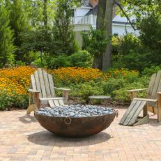 Fire Pit And Adirondack Chairs In Backyard