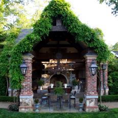 Gorgeous Brick Pavilion and Water Feature in Sunny Garden With Wisteria and Iron Decor 