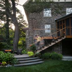 Gray Stone Home Exterior With Elevated Stone Patio, Fire Pit