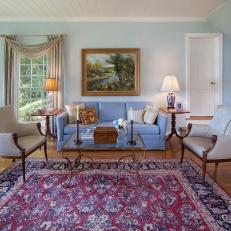Traditional Living Room Features Exciting Antique Glass Coffee Table, Elegant Seating & Area Rug