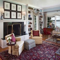 Elegant Living Room Features Elegant Rugs, Built-In Shelves & A Grand Fireplace