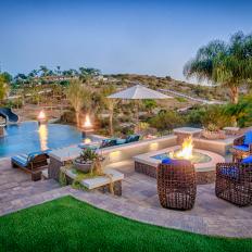 Tropical Pool Deck With Stone Fire Pit, Unique Wicker Chairs With Blue Cushions and Scenic View 