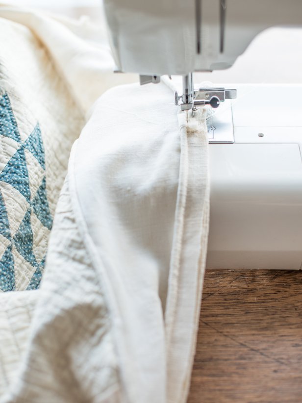 Turn slipcover inside out onto ottoman again. Pin piping that will run along bottom edge of ottoman side, where skirt will be attached.  Sew it on and remove pins.