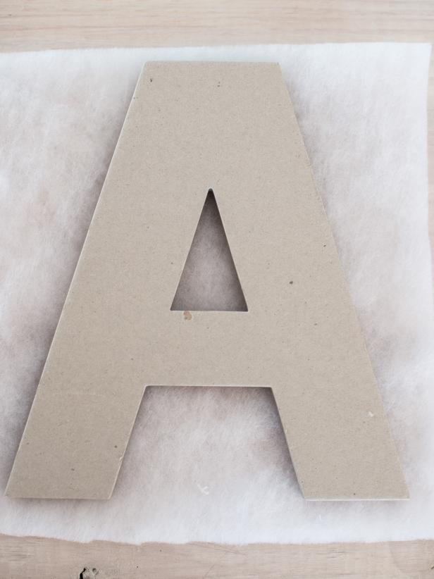 Place each letter on one layer of lightweight quilt batting and trace the letter onto the batting with permanent marker.  Use scissors to cut out each letter along drawn lines.