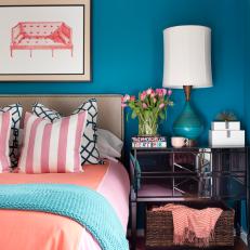 Blue Bedroom With Coral Linens and Mirrored Nightstand