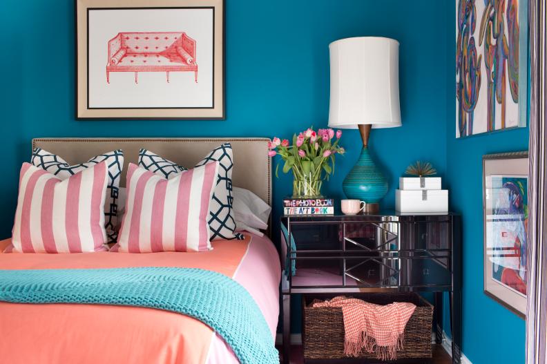 Blue Bedroom With Coral Linens and Mirrored Nightstand