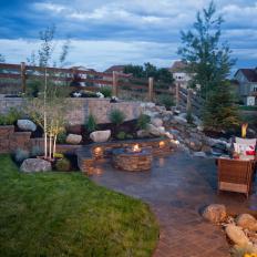 Sloping Stone Walls and Flooring Define a Backyard Landscape 
