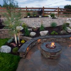 Curved Stone Walls and Fences Add Depth to A Backyard's Platform Seating Area