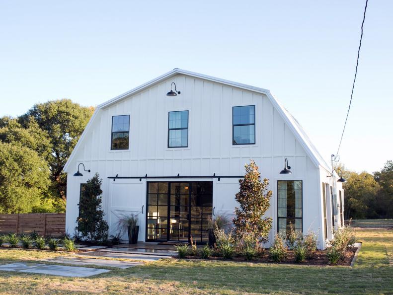 The exterior of the Meek home has been completely transformed with new windows, large sliding barn doors, light fixtures, and landscaping, as seen on Fixer Upper. (exterior)