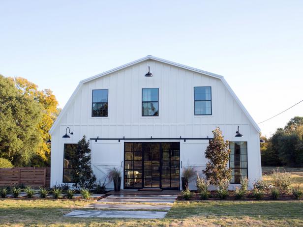 The exterior of the Meek home has been completely transformed with new windows, large sliding barn doors, light fixtures, and landscaping, as seen on Fixer Upper. (After #1)