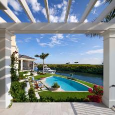Pergola View of Dreamy Swimming Pool and Clean Landscaping of Waterfront Backyard 