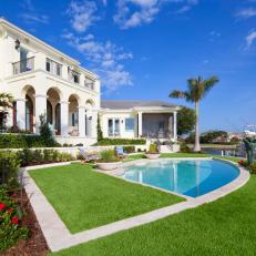 Sunny Waterfront Backyard Swimming Pool and Tiered Planted Landscaping 