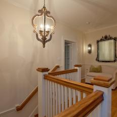 Simple Traditional Style Upstairs Hall With Wood handrail Over White Balusters and Vintage Light Fixture 