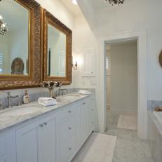 Double-Vanity Traditional Bathroom With Thick Gold Mirror Frames and Marble Detailing 